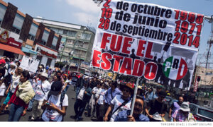 Manifestante con cartel con las represiones del 2 de octubre, el Halconazo y el 26 de septiembre de 2014