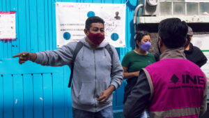 Imagen de una persona del INE hablando con un ciudadano